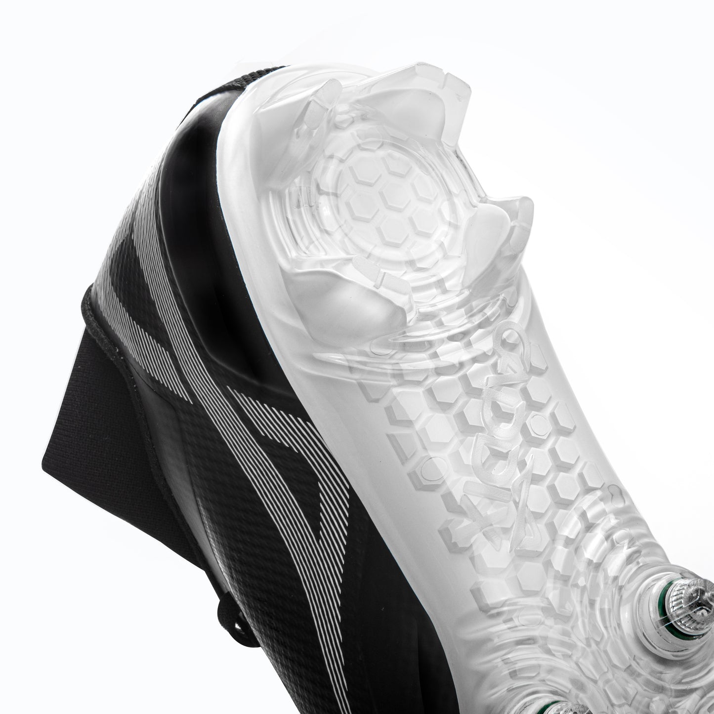 Shot of clear-plastic heel portion of black/white Caddix men’s mid football and lacrosse cleats. Forefoot uses patented Smart Studs to reduce ACL injuries