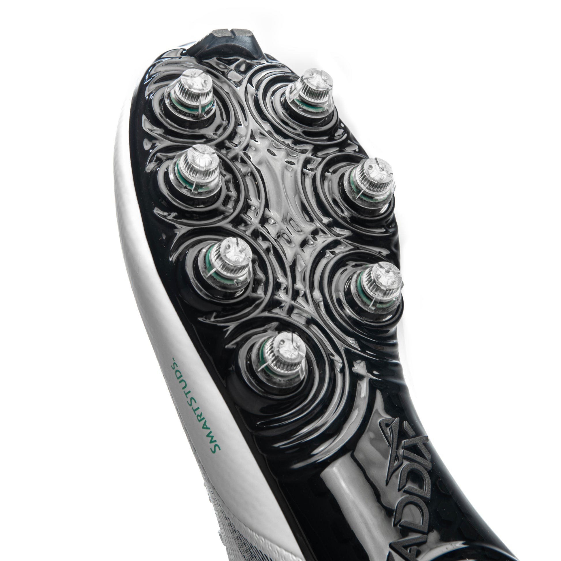 Close-up look at patented Caddix Smart Studs on white/black men’s low cleats designed to minimize knee torque and reduce ACL injury risk