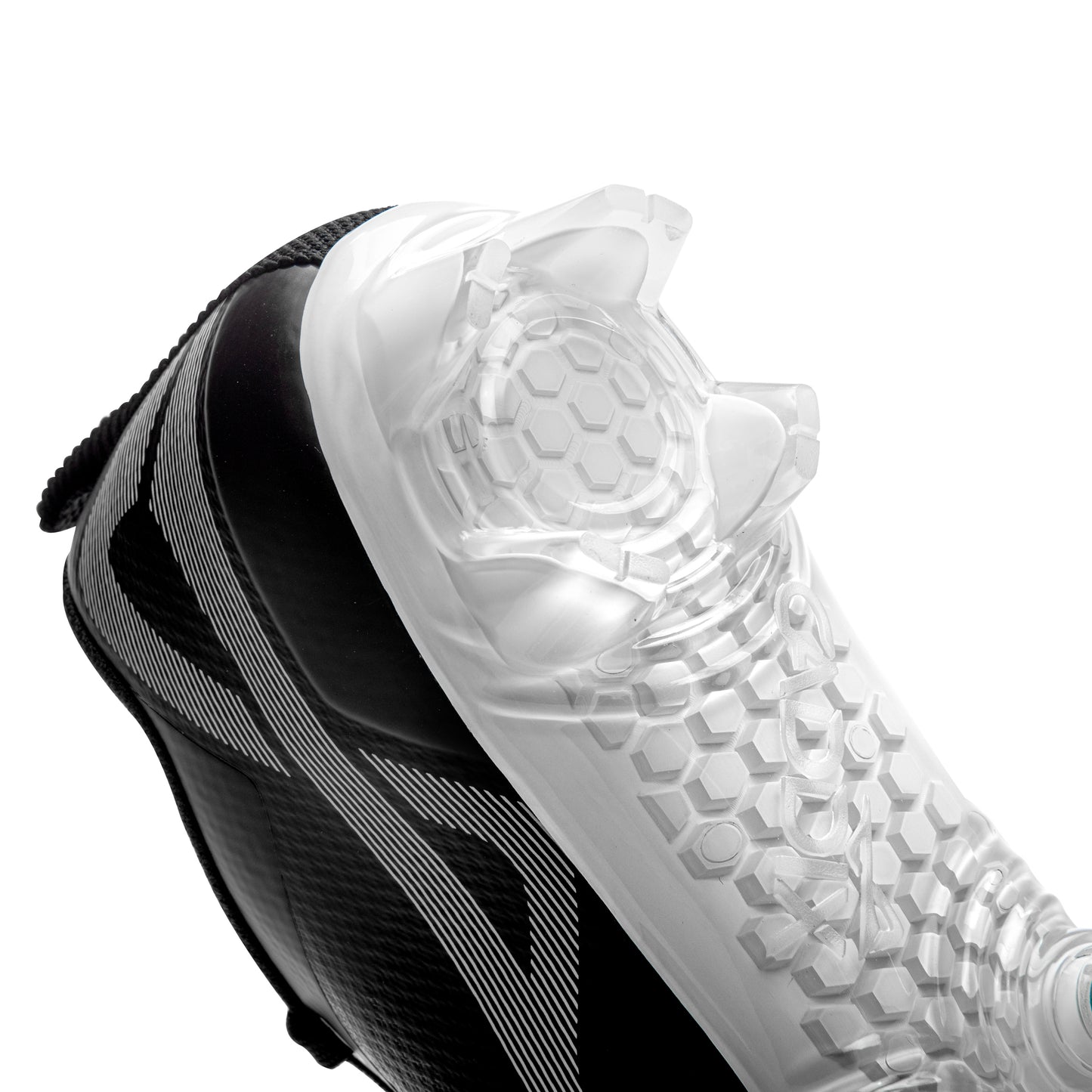 View of bladed heel design on Caddix men’s black/white low football and lacrosse cleats. Patented Smart Studs on forefoot flex to reduce injury-causing torque