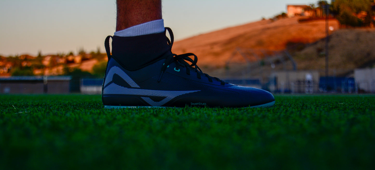 Side of Caddix men's teals mid cut football lacrosse cleats for knee injuries in black teal