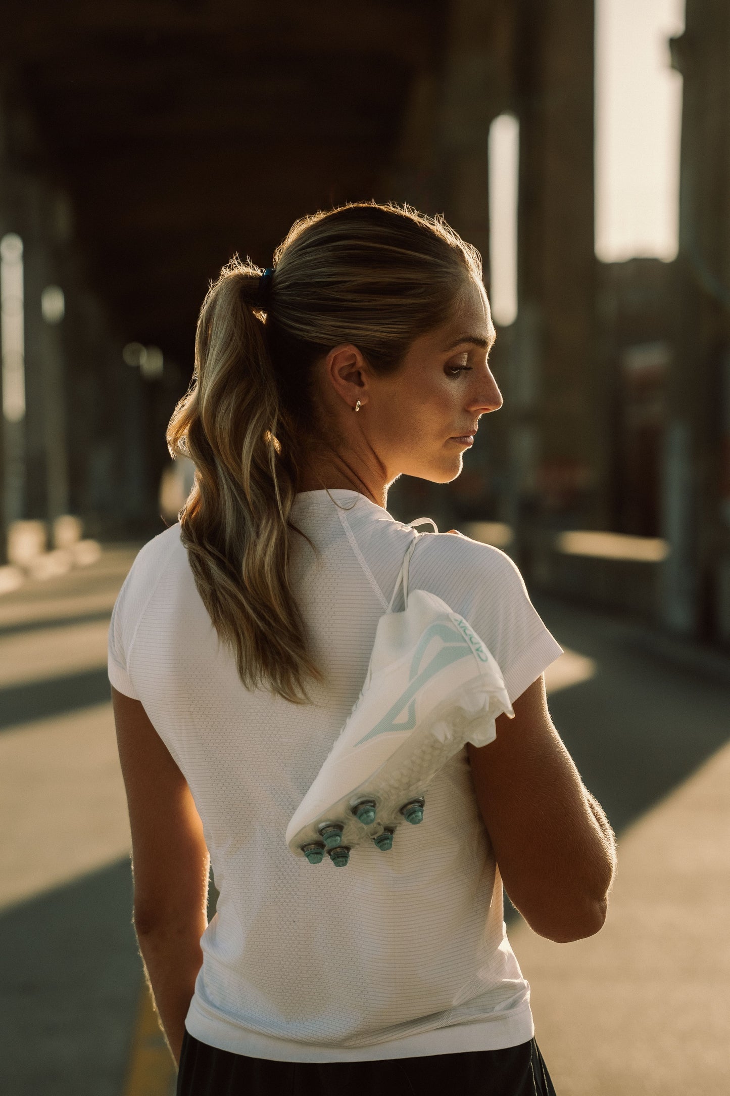 Professional women’s soccer player Kayla Sharples with white/white mid Caddix cleats with patented Smart Stud she depends on to reduce lower leg injuries